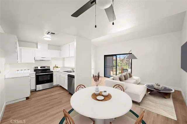 a large kitchen with a table chairs stove and wooden floor