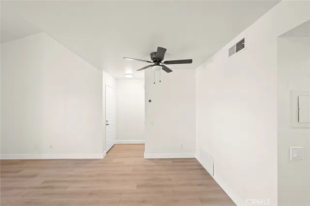a view of a room with wooden floor and a ceiling fan
