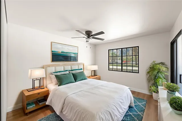 a bedroom with bed mirror and window