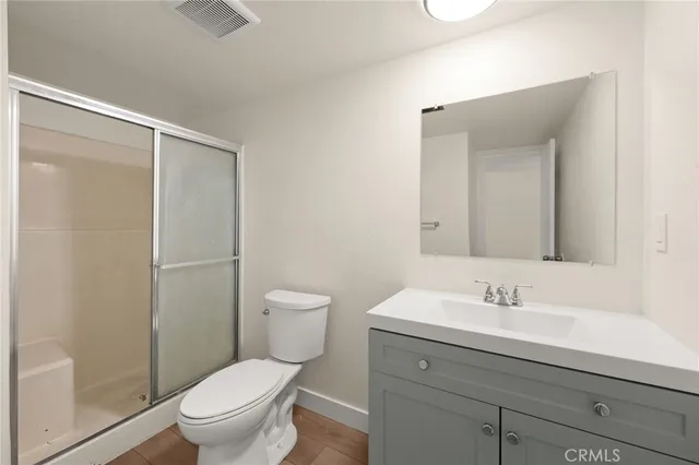 a bathroom with a sink a toilet a mirror and shower