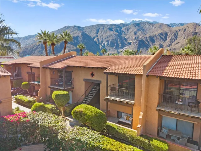 a aerial view of a house with table and chairs under an umbrella