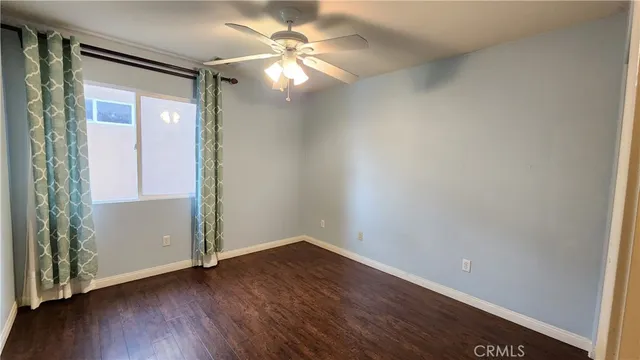 a view of a small space with wooden floor and a chandelier fan