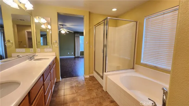 a bathroom with a tub a sink and a large mirror