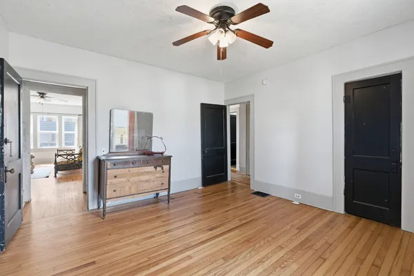 a view of a livingroom with a ceiling fan and wooden floor