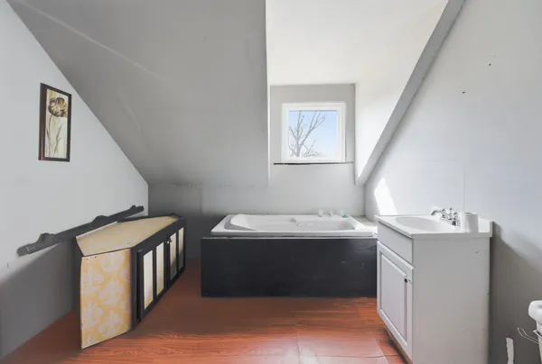 a view of an empty room with closet and a window