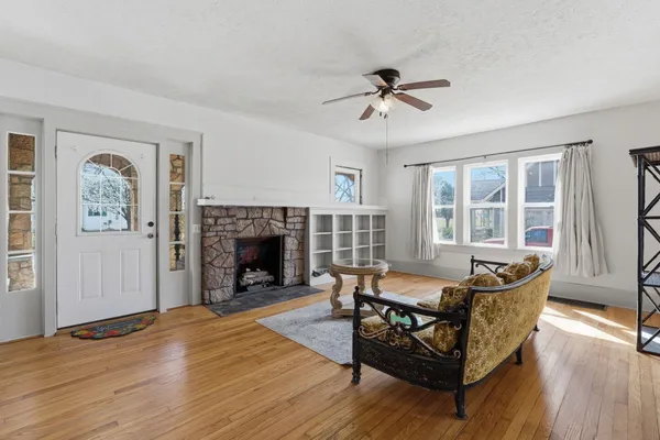 a view of a hallway with wooden floor and a kitchen