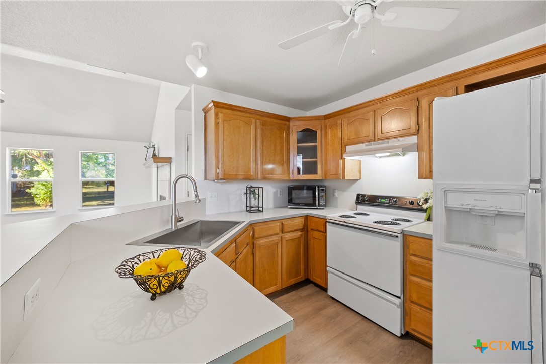 a kitchen with stainless steel appliances granite countertop a sink dishwasher stove and refrigerator