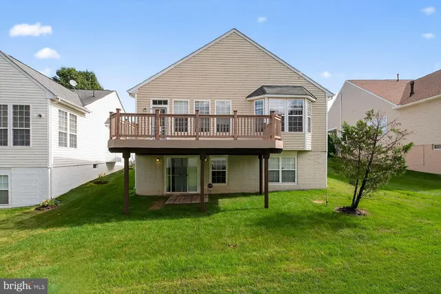 a aerial view of a house next to a yard with potted plants and large windows