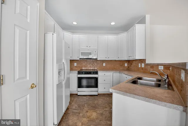 a kitchen with a sink a stove and cabinets