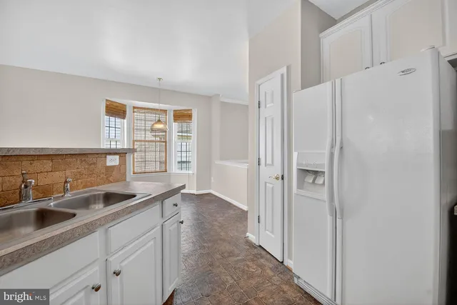 a kitchen with stainless steel appliances granite countertop a sink and a refrigerator