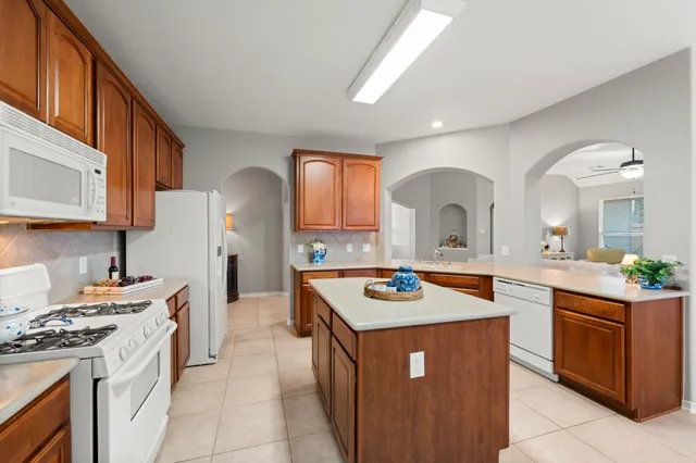 a kitchen with a stove a sink dishwasher and a stove with wooden cabinets