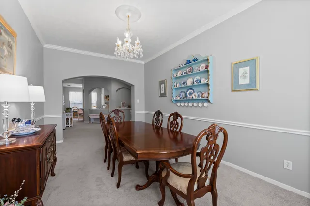 a dining room with furniture a chandelier and window