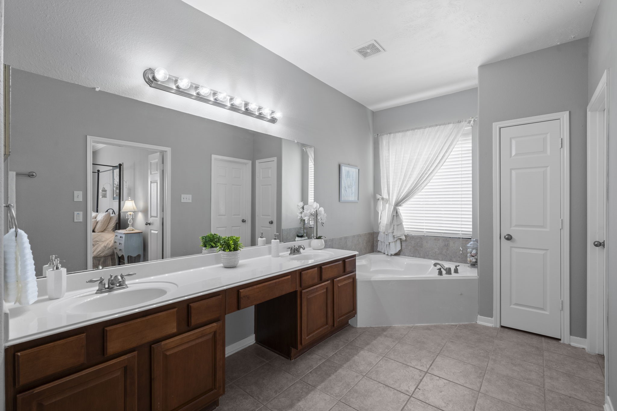 8407 Oak Villa Court Spring, TX 77389 - Photo 28 of 40 a bathroom with a double vanity sink a mirror and a bathtub