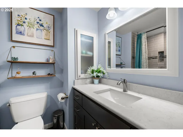 a bathroom with a toilet a sink and mirror