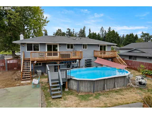 a view of a house with pool and chairs