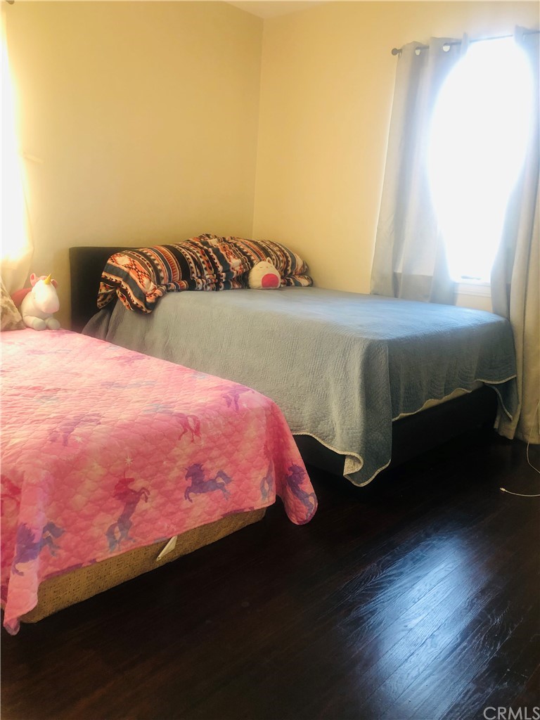 406 West Elm Street Compton, CA 90220 - Photo 2 of 16 a bedroom with a bed and wooden floor