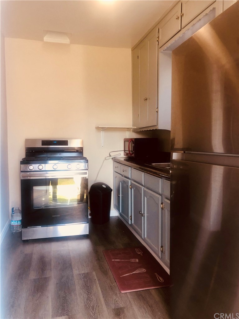 406 West Elm Street Compton, CA 90220 - Photo 5 of 16 a kitchen with granite countertop a stove a sink and a microwave