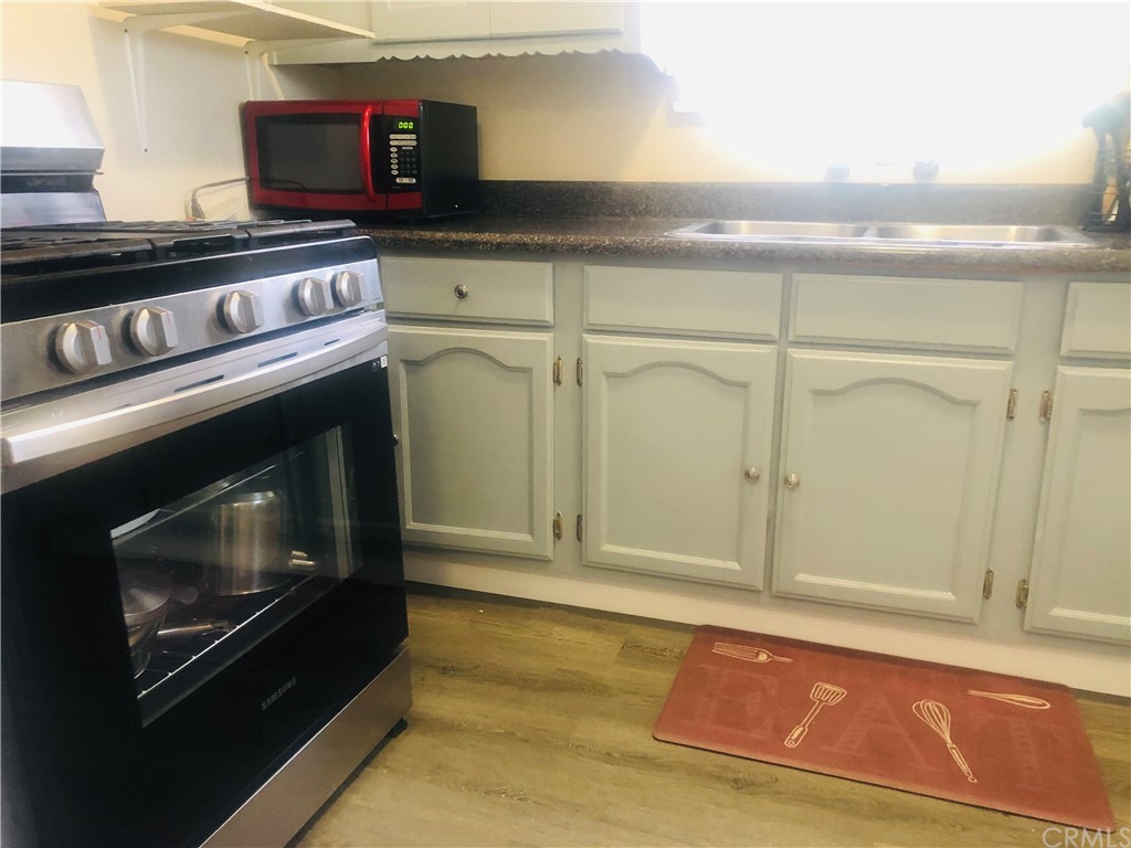 406 West Elm Street Compton, CA 90220 - Photo 6 of 16 a kitchen with granite countertop a stove and a microwave