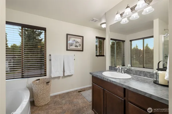 a bathroom with a toilet sink vanity and mirror
