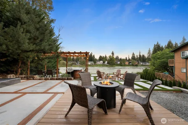 a view of a lake with couches and wooden fence