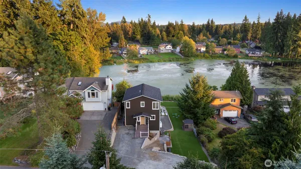an aerial view of a house with a yard and lake view