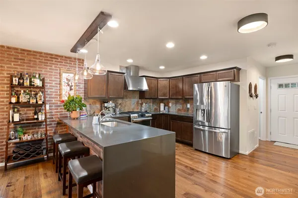 a kitchen with a refrigerator a stove and a wooden floor