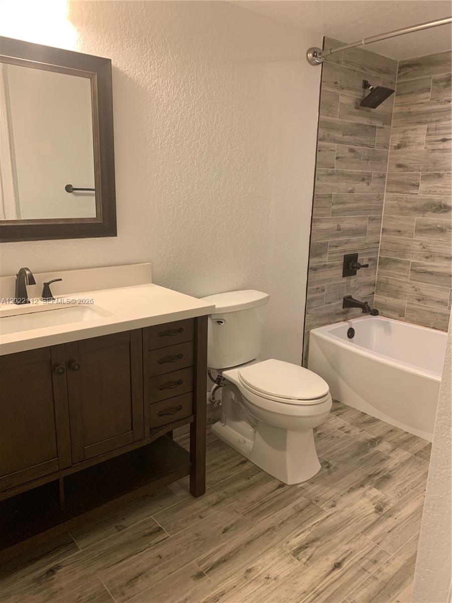 6572 West Sample Road, Unit 6572 Coral Springs, FL 33067 - Photo 10 of 17 a bathroom with a toilet a sink and mirror