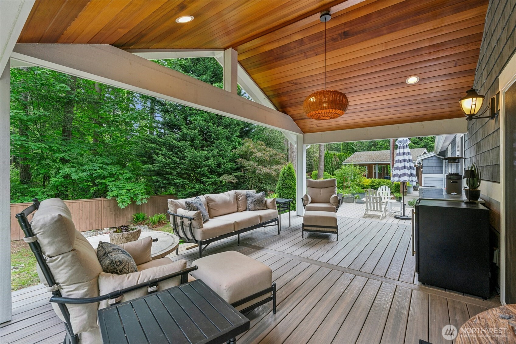 23307 49th Avenue Southeast Bothell, WA 98021 - Photo 22 of 37 a view of a patio with couches and chairs under an umbrella with a barbeque