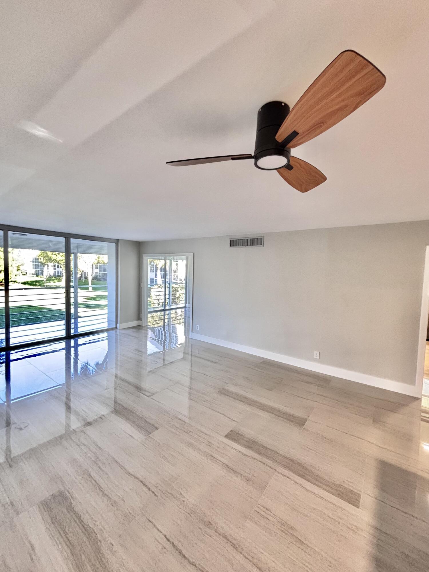545 Oaks Lane, Unit 201 Pompano Beach, FL 33069 - Photo 2 of 22 an empty room with wooden floor and windows
