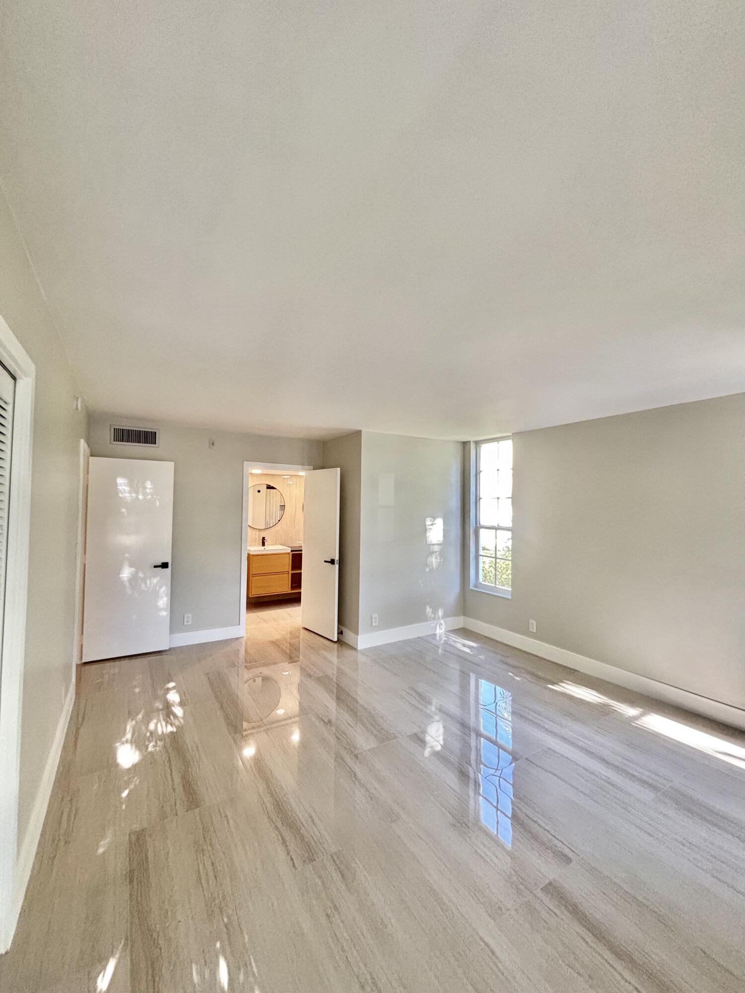 545 Oaks Lane, Unit 201 Pompano Beach, FL 33069 - Photo 10 of 22 an empty room with wooden floor and windows