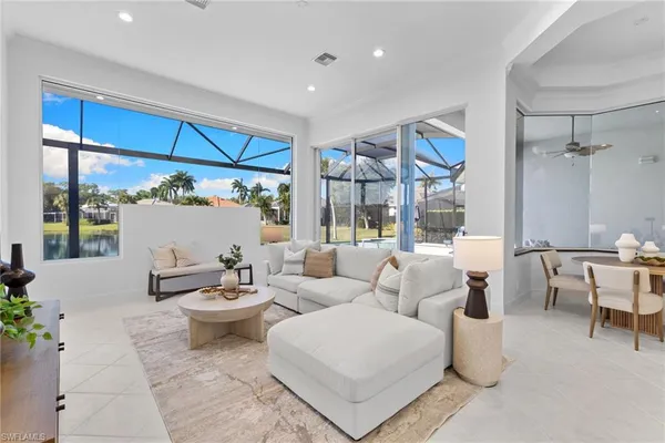 a living room with furniture a large window and a table