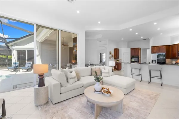 a living room with furniture and a view of kitchen