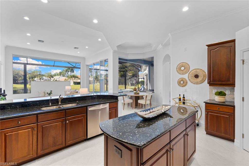 1624 Manchester Court Naples, FL 34109 - Photo 18 of 49 Kitchen featuring dark stone counters, a center island, ornamental molding, dishwasher, and recessed lighting