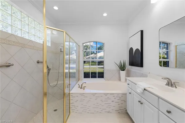 a bathroom with a granite countertop tub sink a mirror a shower and vanity