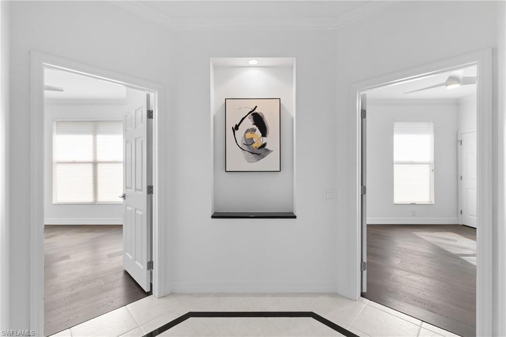 1624 Manchester Court Naples, FL 34109 - Photo 28 of 49 Hall with crown molding, inlaid floor details, and light tile patterned floors
