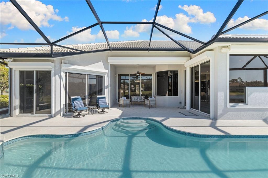1624 Manchester Court Naples, FL 34109 - Photo 41 of 49 Rear view of house with a sunroom, a ceiling fan, an outdoor pool, a tiled roof, and a patio area