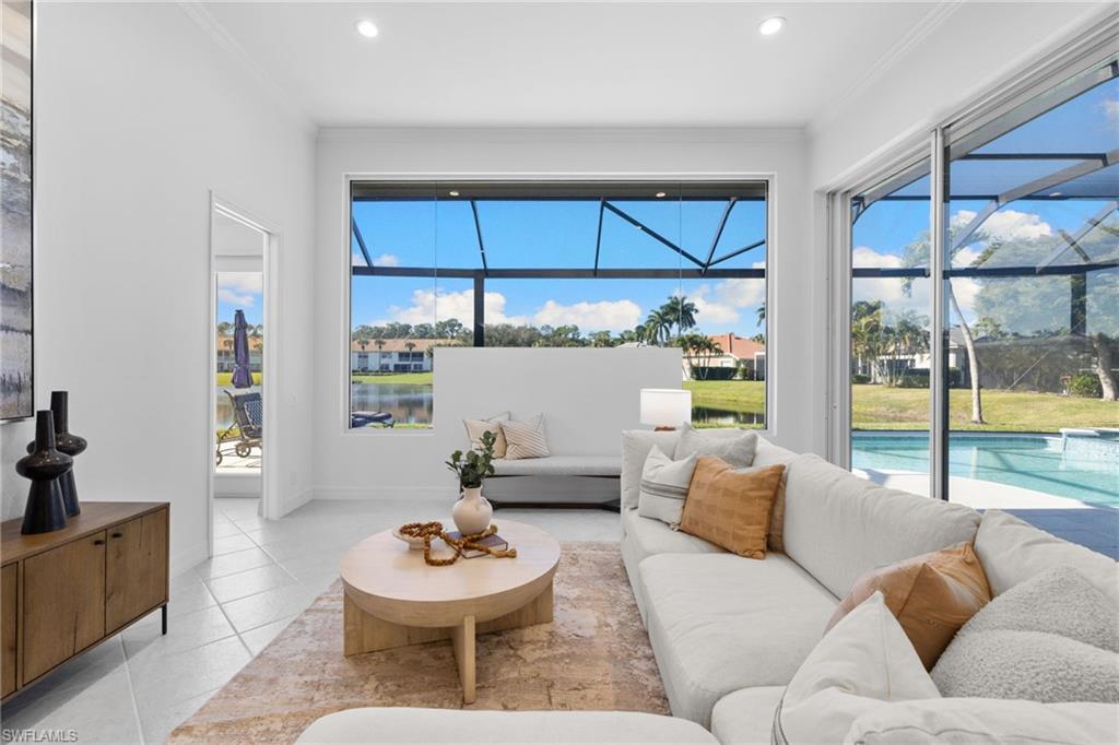 1624 Manchester Court Naples, FL 34109 - Photo 10 of 49 Living area with light tile patterned floors, a sunroom, a water view, ornamental molding, and recessed lighting