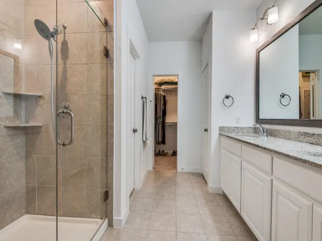a bathroom with a granite countertop sink mirror and shower