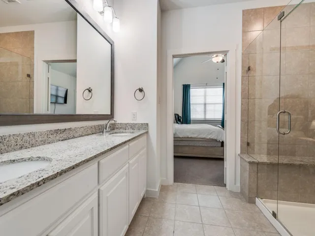 a en suite bathroom with a granite countertop sink and a mirror