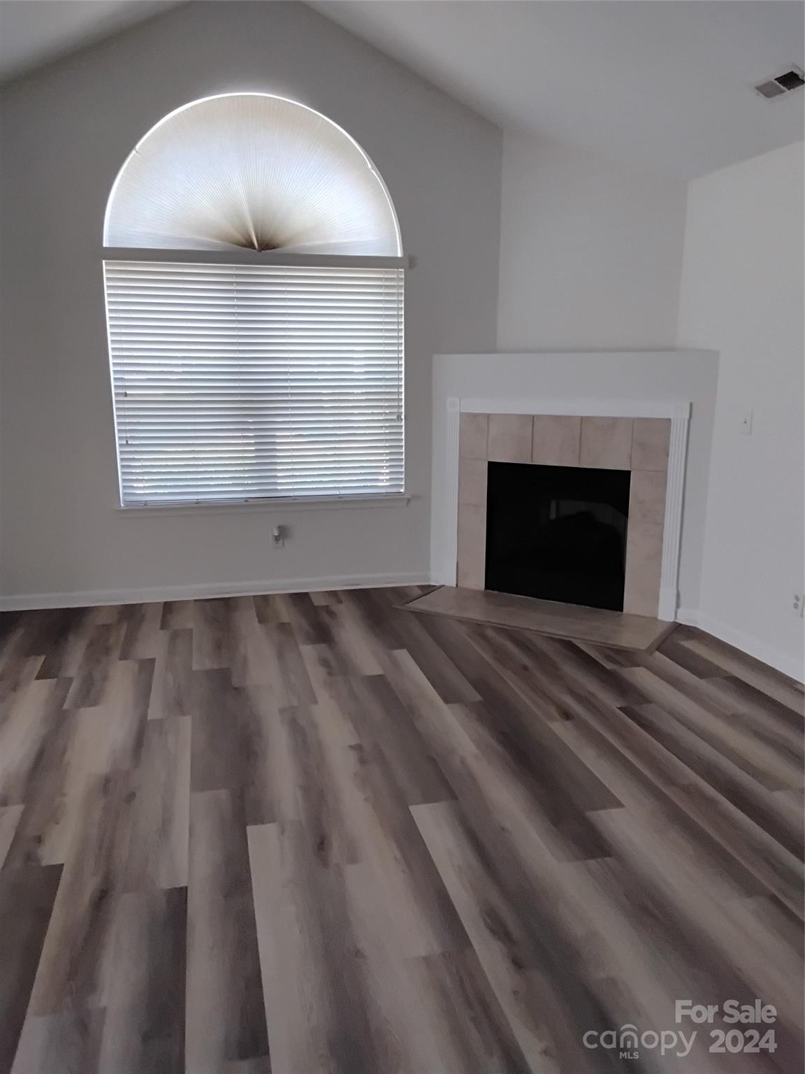 817 Ledgestone Court Fort Mill, SC 29708 - Photo 6 of 36 an empty room with wooden floor windows and a fireplace