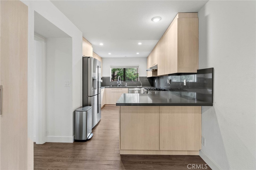 5757 Owensmouth Avenue, Unit 1 Woodland Hills, CA 91367 - Photo 22 of 42 a kitchen with stainless steel appliances granite countertop a refrigerator and a sink