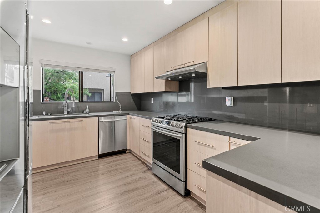 5757 Owensmouth Avenue, Unit 1 Woodland Hills, CA 91367 - Photo 23 of 42 a kitchen with granite countertop white cabinets and white appliances