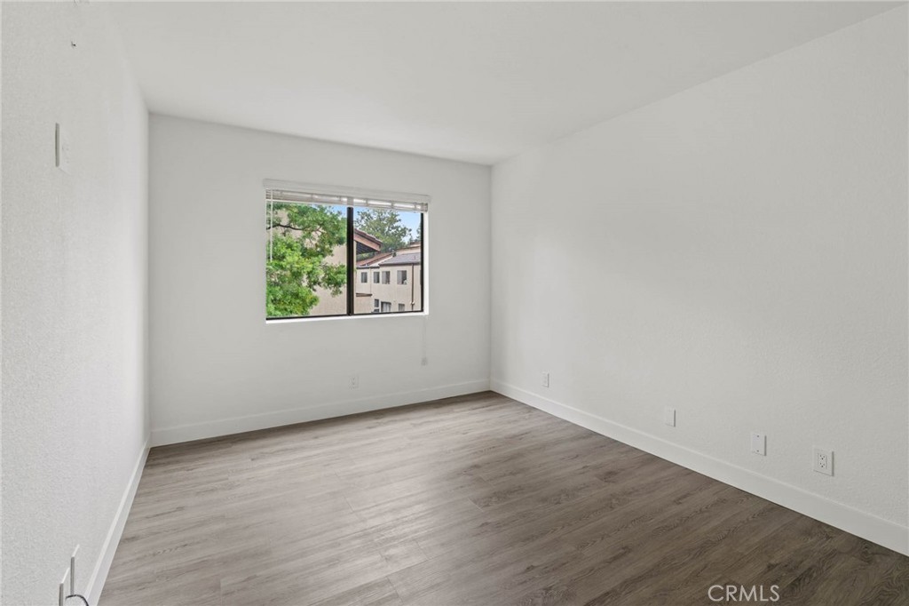 5757 Owensmouth Avenue, Unit 1 Woodland Hills, CA 91367 - Photo 31 of 42 an empty room with wooden floor and windows