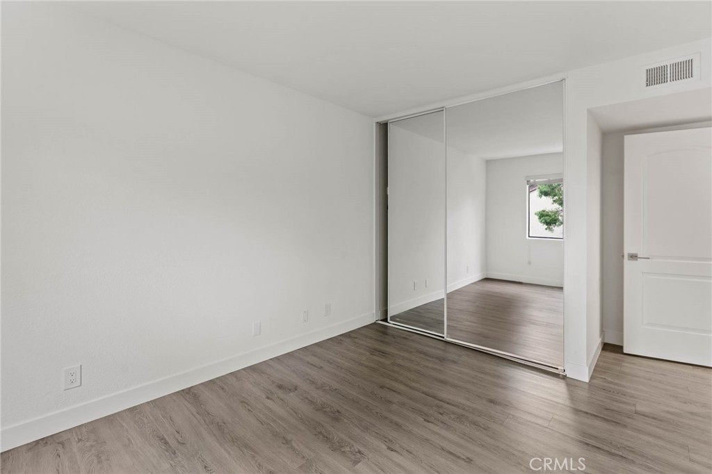 5757 Owensmouth Avenue, Unit 1 Woodland Hills, CA 91367 - Photo 32 of 42 an empty room with wooden floor & windows