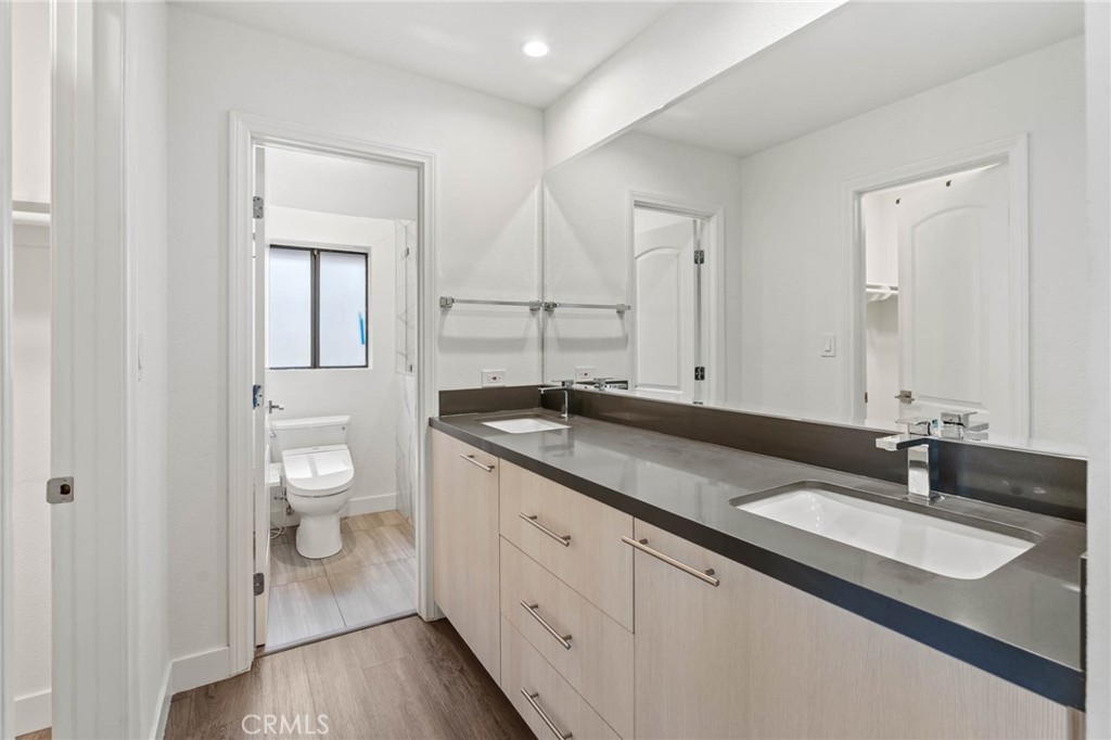 5757 Owensmouth Avenue, Unit 1 Woodland Hills, CA 91367 - Photo 35 of 42 a spacious bathroom with a granite countertop sink a toilet and a mirror
