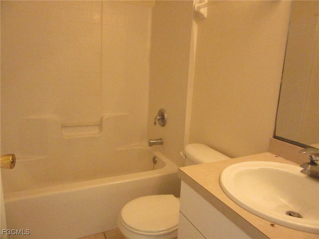 4546 28th Street Southwest Lehigh Acres, FL 33973 - Photo 4 of 9 a white toilet sitting next to a bath tub