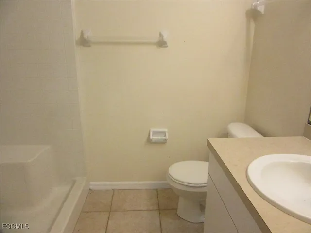a white toilet sitting next to a white sink and vanity