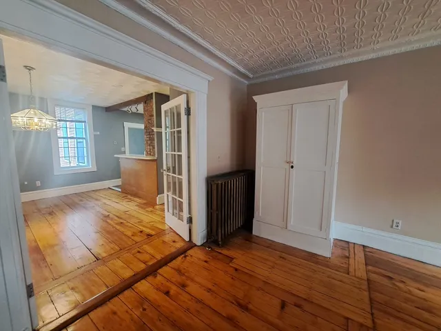 a view of a livingroom with wooden floor and a flat screen tv