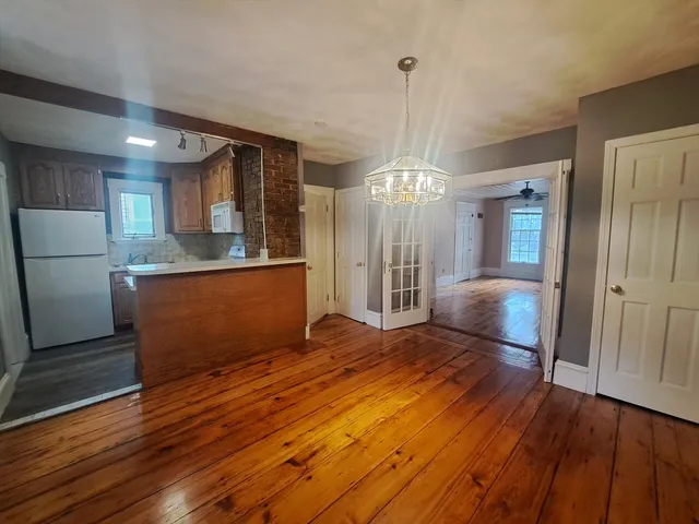 a view of a kitchen with wooden floor and a kitchen