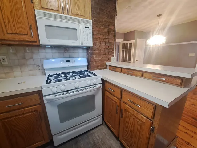 a kitchen with granite countertop a stove sink and cabinets